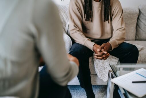 Black man receiving mental health care treatment from black healthcare professional