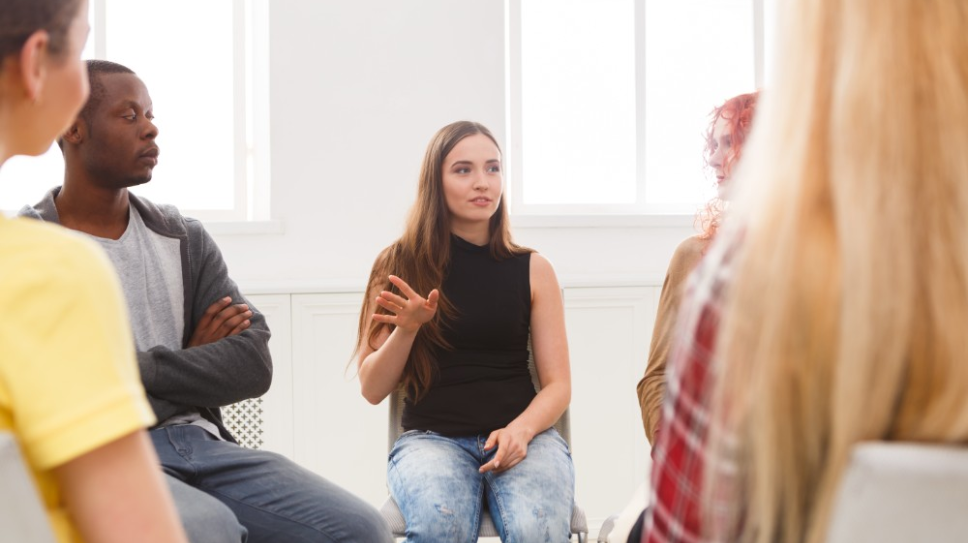 Group of young people talking in a group therapy session