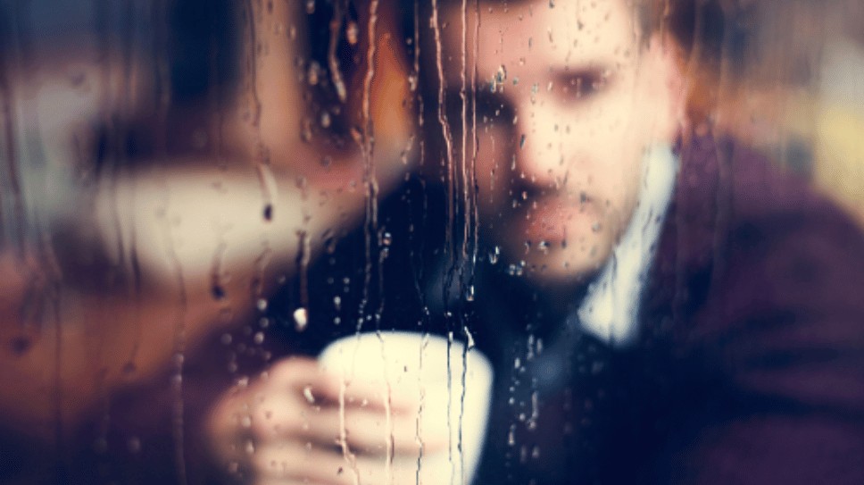 Businessman looking out a rainy window