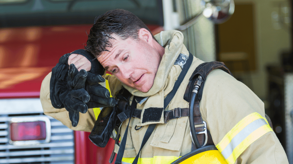 Firefighter looking tired and wiping brow